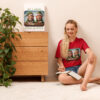 Woman in elf-themed shirt sitting, writing in notebook.