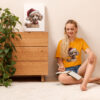 Woman with notebook, wearing dog t-shirt, near plant