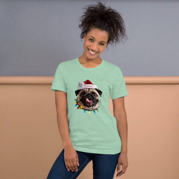 Woman wearing Christmas pug T-shirt, smiling indoors.